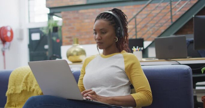 Happy african american businesswoman using laptop at office