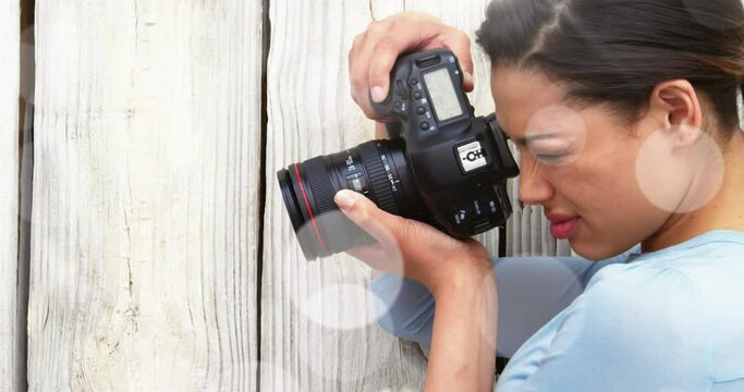 White spots against close up of caucasian female photographer clicking pictures with digital camera