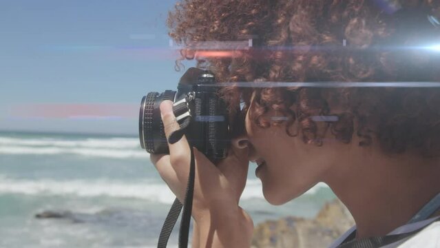 Spot of light against african american female photographer clicking pictures with digital camera