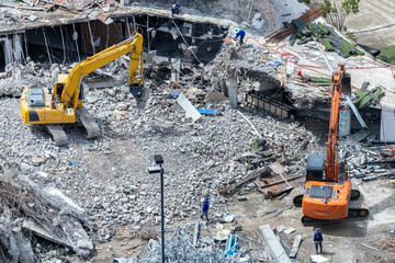 Aerial view Hydraulic scissors on rigging to cut abandoned buildings destroy building, Hydraulic...