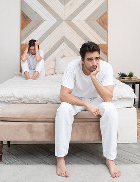Frustrated and depressed man sitting on the edge of the bed after conflict with his wife because of his erectile dysfunction problem