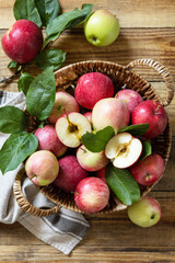 Organic fruits. Fall harvest background. Farmer's market. Basket of ripe apples on a rustic wooden table. View from above.