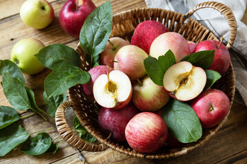 Organic fruits. Fall harvest background. Farmer's market. Basket of ripe apples on a rustic wooden table.