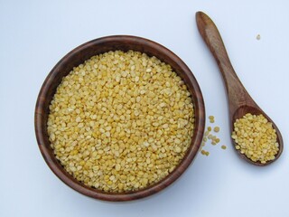 Moong dal in a wooden bowl isolated on white background 
