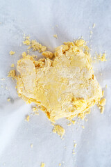 homemade puff pastry dough on white parchment paper background..
