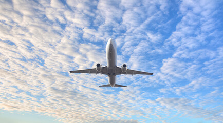 Fototapeta na wymiar White passenger airplane flying in the sky amazing clouds in the background - Travel by air transport