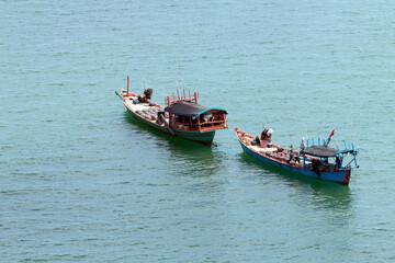 Two red wooden boat full of catch in the sea