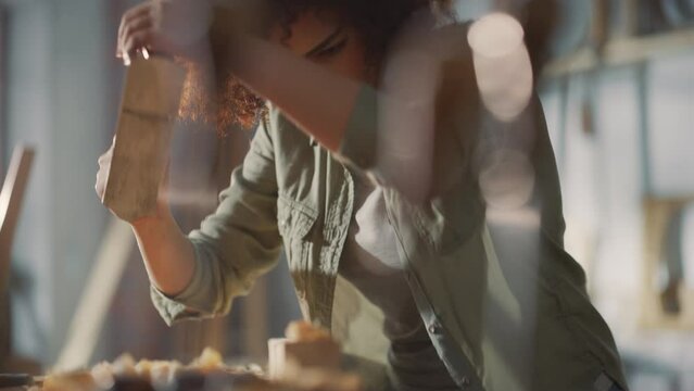 Close Up Portrait of a Young Female Artisan Carpenter Using Hand Plane to Shape a Wood Bar. Beautiful Artist Working on a Project in a Woodworking Workshop.