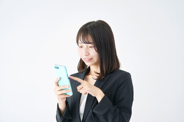 白背景でスマホを使うビジネスウーマン