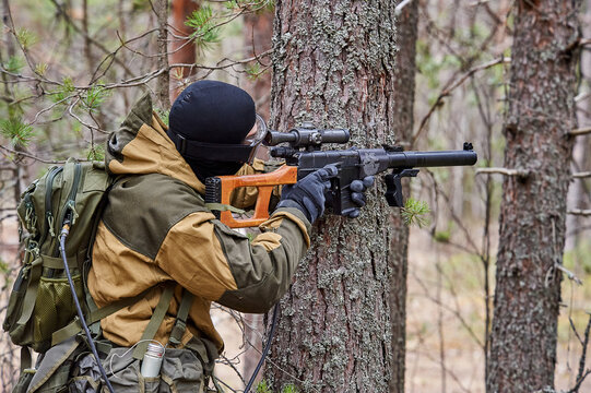 a man in the forest shoots from a machine gun