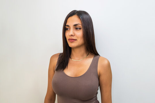 Close-up of a beautiful sexy brunette with a big bust on a white background.