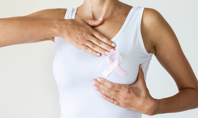 Woman with pink ribbon symbol of breast cancer awareness month.