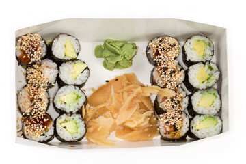 Different sushi with condiments in cardboard packaging for take-out