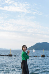 Fototapeta na wymiar 海で撮影するカメラ女子