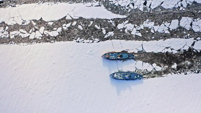 Aerial view of icebreakers on river crushing the ice.
