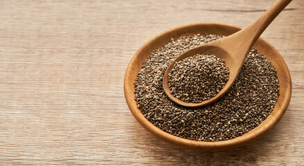 chia seed in wood plate and spoon on wooden table background                                      
