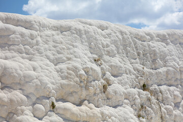Fototapeta na wymiar A mountain of white volcanic limestone rock against a blue sky.