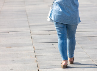 Woman in jeans walking down the road