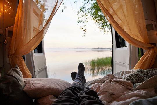 Feet of person lying in bed in camper van