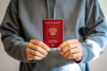 Russian passport in the hands of a man. Prohibition of Schengen visas for Russian tourists to travel to the European Union concept. - obrazy, fototapety, plakaty
