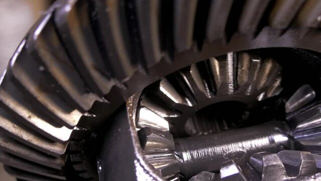 A mechanism with rotating gears. Reducer from the middle. Metal construction from spare parts. Traction rotation transmission. Stopping and starting the engine.