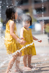 駅前広場の噴水で水浴びして遊んでいる女の子