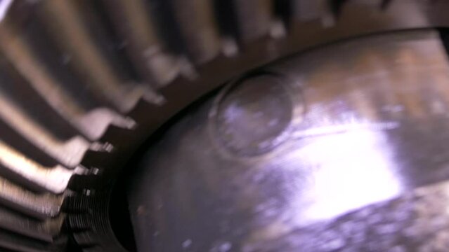 A mechanism with rotating gears. Reducer from the middle. Metal construction from spare parts. Traction rotation transmission. Stopping and starting the engine.