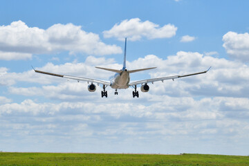 Avion de aerolinea aterrizando en un aeropuerto con cielo con nubes