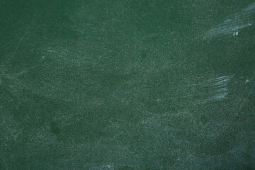 The texture of a green school chalkboard stained with chalk. School education.