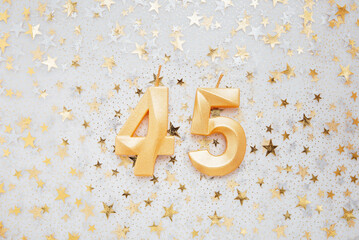 Number 45 forty five golden celebration birthday candle on Festive Background. forty five years birthday. concept of celebrating birthday, anniversary, important date, holiday