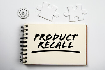 PRODUCT RECALL. Notepad, puzzle pieces and gear on white office table