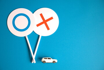 マルバツのフリップと車と青背景の左寄りの写真