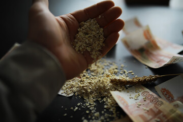 The concept of the cost of grain. 5000 ruble banknotes around a handful of ground grain. World hunger.
