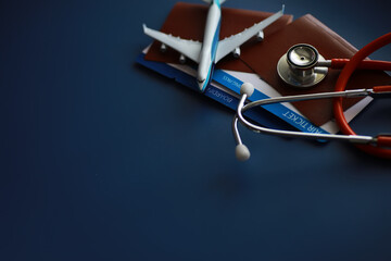Passenger air insurance concept. Airplane, passport, boarding pass and stethoscope.