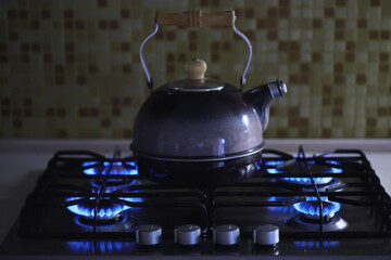 Kettle with a whistle on the gas stove. Built-in gas panel. The kettle is on the stove.Gas crisis