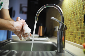 Man washing dish in sink at restaurant.People are washing the dishes too Cleaning solution