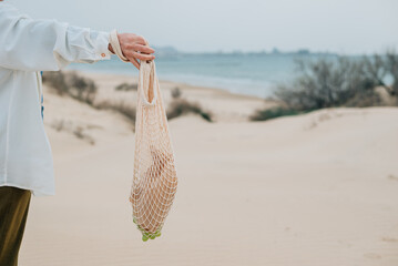 Close-up. An adult woman holds a shopping bag with breakfast, a snack grapes, a croissant in...
