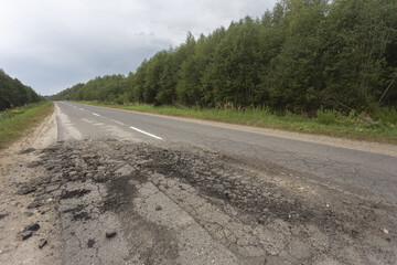 The texture of cracked old asphalt in need of repair. The road is full of holes and potholes.
Hole in the asphalt, risk of movement by car, bad asphalt, dangerous road.