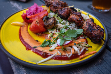 Fried pork loin nuggets with cooked vegetables on wooden table