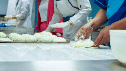 Obraz na płótnie Canvas masters prepare food by rolling dough