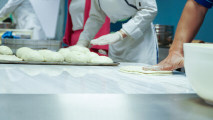 Obraz na płótnie Canvas masters prepare food by rolling dough