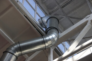 Curved ventilation pipe passing under the roof of the workshop