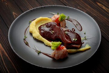 Lamb tongues with mashed potatoes on a wooden background