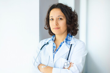 Doctor with stethoscope crossing arms looking into the camera