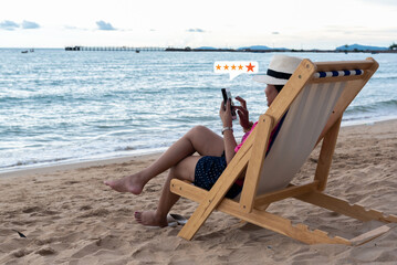 Young Asian happy woman using smartphone on the beach ,customer service and five stars satisfaction...