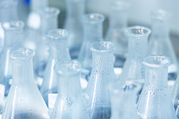 Flasks with transparent liquid and steam in laboratory for standard curve analysis concentration range of total iron in transparent flasks..