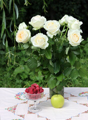 Bouquet of white roses on a garden table. Simple composition still life with flowers. Summer day in a garden. 