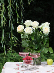 Bouquet of white roses on a garden table. Simple composition still life with flowers. Summer day in a garden. 