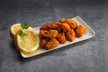 nuggets on a white plate on cement background, lid food