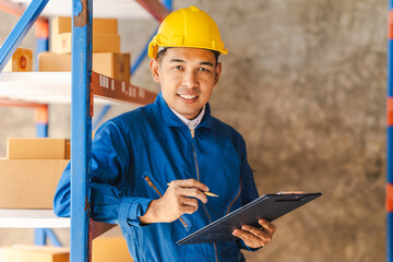 Fototapeta premium Business Asian warehouse worker checking packages in storehouse and holding paper clipboard.